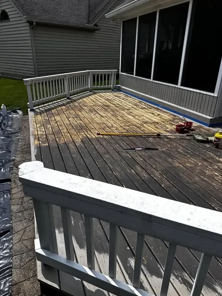 Dark, weathered deck with worn stain before power washing