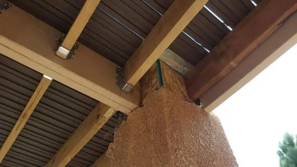 Underside of a deck showing new joists, hangers, and a beam