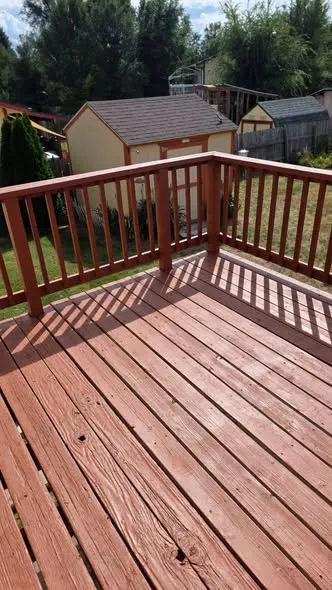 Red-stained deck boards and railing after rotted boards were replaced